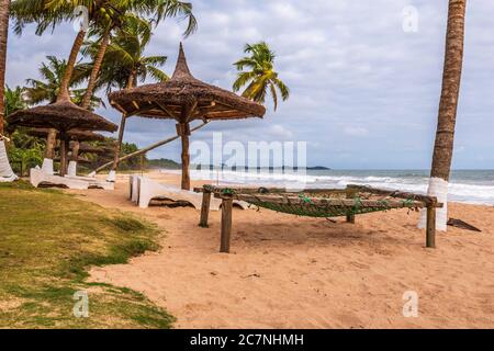Axim spiaggia con palme da cocco e lettini sulla costa dorata del Ghana Africa occidentale Foto Stock