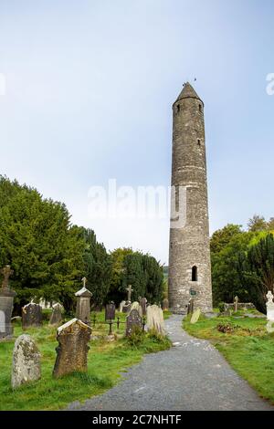 La Torre rotonda a Glendalough con cimitero in primo piano Foto Stock