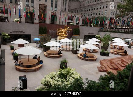 Scena all'atrio del Rockefeller Center durante il coronavirus o la pandemia del covid-19, con pochissime persone sedute e distanziate sociali Foto Stock