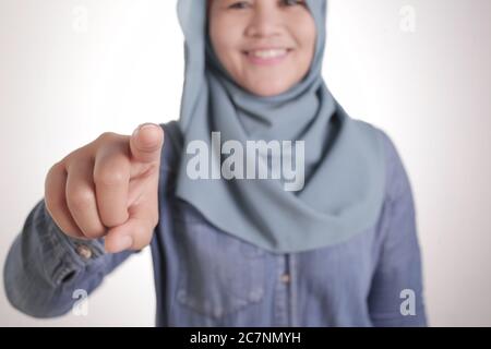 Ritratto di donna musulmana asiatica che indossa hijab puntando in avanti alla fotocamera come se la scelta voi gesto, business reclutamento concetto di assunzione Foto Stock