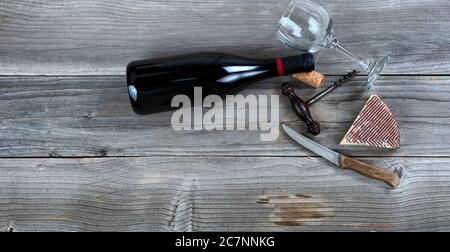 Spicchio di formaggio fresco e vino rosso su legno rustico Foto Stock