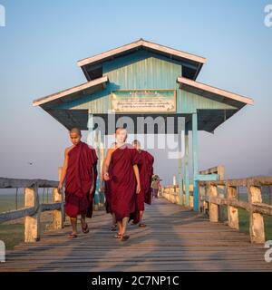 I giovani monaci camminano sul Ponte U Bein a Mandalay, Myanmar Foto Stock