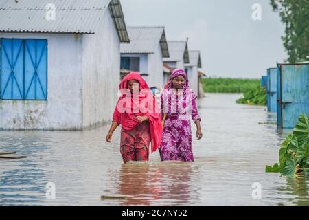 Bogura, Bangladesh. 15 luglio 2020. Donne che camminano su un sentiero allagato.almeno 1.5 milioni di persone sono state colpite, con case e strade nei villaggi allagati. I funzionari del Centro di previsione e allarme delle inondazioni (FFWC) hanno riferito che la situazione delle inondazioni in 15 distretti centrali e settentrionali è stata dovuta all'aumento dei livelli d'acqua dei principali fiumi, tra cui Brahmaputra, Jamuna, Padma, Teesta e Dharla. Credit: Zabed Hasnain Chowdhury/SOPA Images/ZUMA Wire/Alamy Live News Foto Stock