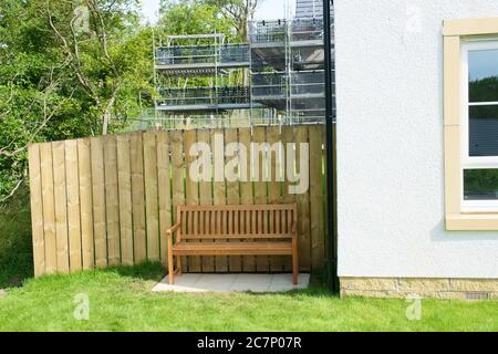 Panca in legno di quercia per giardino su prato della casa Foto Stock