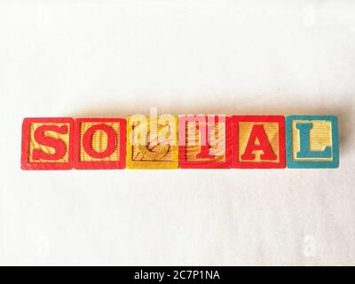 Primo piano di cubi colorati che scrivono la parola 'sociale' con un sfondo bianco Foto Stock