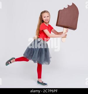 ritratto di carina bambina che tiene enorme gelato su sfondo bianco Foto Stock