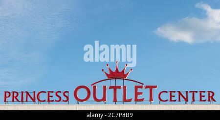 Scritta luminosa e vivace e logo LED rosso al neon per il Princess Outlet Center sul tetto dell'edificio contro il cielo blu a Sofia Bulgaria Foto Stock