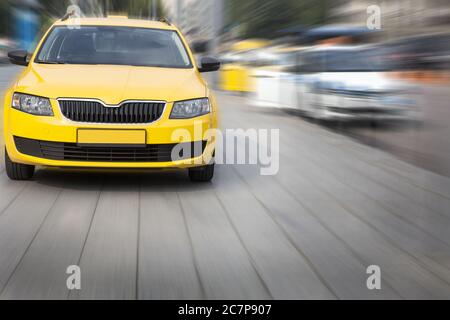 Taxi giallo si muove sulla strada di città Foto Stock