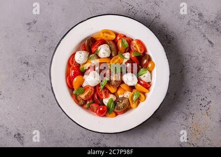 Insalata caprese tradizionale fatta di pomodori freschi a fette, mozzarella e basilico, vista dall'alto Foto Stock