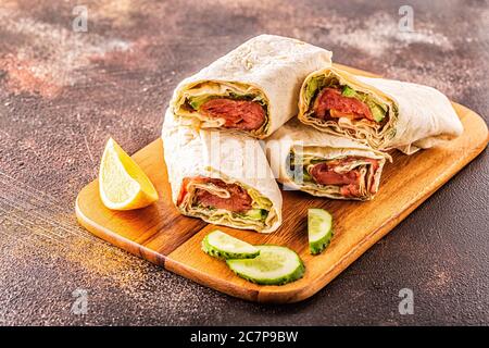 Sandwich avvolto con salmone, lattuga, cetrioli e crema di formaggio, fuoco selettivo. Foto Stock