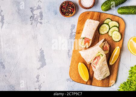 Sandwich avvolto con salmone, lattuga, cetrioli e formaggio cremoso, vista dall'alto. Foto Stock