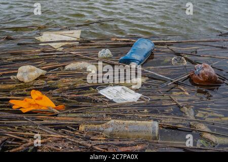 Il coronavirus sta contribuendo all'inquinamento, come maschere di faccia scartate disordine fiume Danubio fiume fiume con plastica e altri rifiuti. Bottiglie di plastica e altri detriti di plastica galleggiano nel Danubio. La plastica e altri rifiuti provenienti da tutta Europa vengono spazzati via dal Danubio nel Mar Nero. Foto Stock