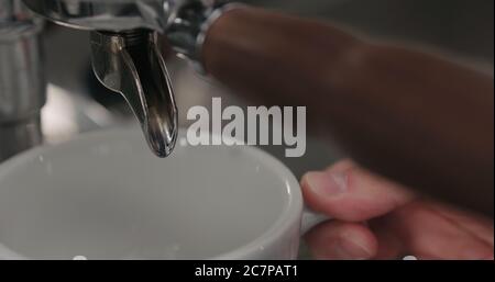 Sciacquare la macchina per il caffè e riscaldare la tazza prima di versare l'espresso Foto Stock