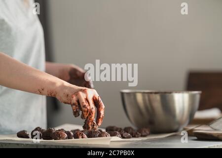 giovane donna che fa caramelle al tartufo in cucina Foto Stock