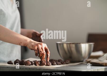 giovane donna che fa caramelle al tartufo in cucina Foto Stock