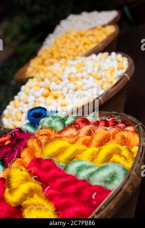 Colorati fili di Seta Tailandese e Cocoon in cestini Foto Stock