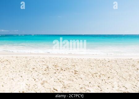 Onda del mare sulla spiaggia di sabbia a Punta Cana, Repubblica Dominicana. Sfondo estivo d'epoca. Foto Stock