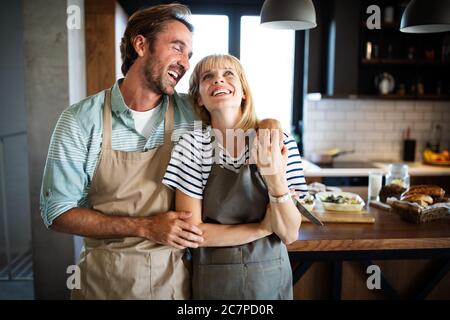 Coppia felice per la cottura di alimenti sani e divertirsi insieme nella loro cucina Foto Stock