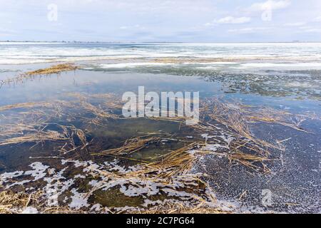 paesaggio del lago d'inverno fiume congelato. l'acqua scioglie la neve, l'inizio della primavera Foto Stock