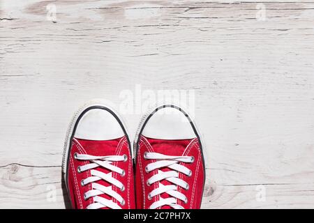 Vecchie scarpe rosse su sfondo di legno Foto Stock