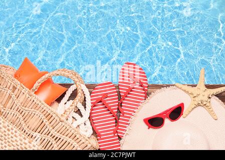 Accessori da spiaggia sul bordo della piscina Foto Stock