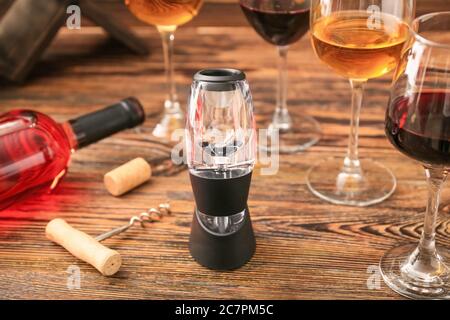 Aeratore per vino con bottiglia e bicchieri su fondo di legno Foto stock -  Alamy