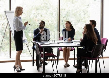 Le persone multietniche che partecipano a una riunione educativa per seminari si siedono nella sala riunioni Foto Stock