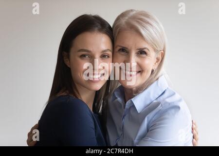 Headshot closeup ritratto maturo madre e figlia adulta abbracciare Foto Stock
