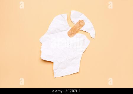 Carta strappata testa umana con intonaco su sfondo colorato. Concetto di demenza Foto Stock