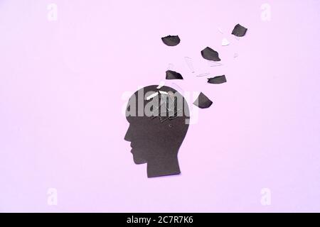 Carta testa umana con pezzi su sfondo a colori. Concetto di demenza Foto Stock
