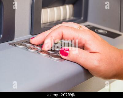 Primo piano di una mano femminile premendo i pulsanti su un Tastiera ATM Foto Stock