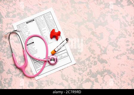 Campione di sangue in provetta con stetoscopio, modello di test tiroideo e di laboratorio su sfondo a colori Foto Stock