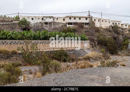 Schiera a schiera di vecchie case operaie finca derelict sopra un barranco a Playa San Juan, Tenerife, Isole Canarie, Spagna Foto Stock