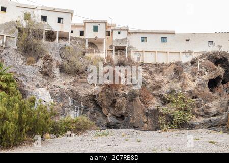 Schiera a schiera di vecchie case operaie finca derelict sopra un barranco a Playa San Juan, Tenerife, Isole Canarie, Spagna Foto Stock