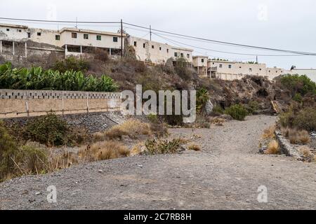 Schiera a schiera di vecchie case operaie finca derelict sopra un barranco a Playa San Juan, Tenerife, Isole Canarie, Spagna Foto Stock