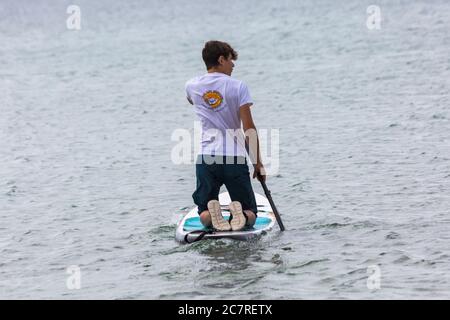 Poole, Dorset UK. 19 luglio 2020. Tempo in Gran Bretagna: A differenza di un giorno caldo di sole, un grigio inizio di giornata a Poole spiagge. Paddleboarder. Credit: Carolyn Jenkins/Alamy Live News Foto Stock