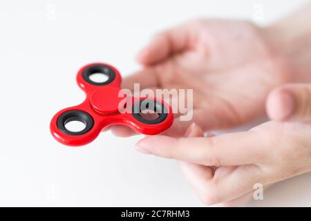 primo piano di fidget spinner in mani femminili su sfondo bianco Foto Stock