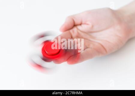 primo piano di fidget spinner che ruota sulla mano femminile su sfondo bianco Foto Stock