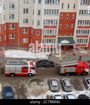 Motore antincendio nel cortile di un edificio residenziale a più piani in inverno. Foto Stock