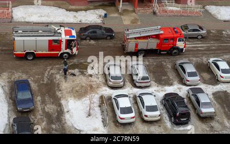 Motore antincendio nel cortile di un edificio residenziale a più piani in inverno. Foto Stock