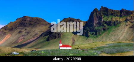 Splendida vista sulla chiesa cristiana di Vikurkirkja di fronte alla mouintaine. Immagine panoramica della più popolare destinazione turistica. Località: Vik villaggio in Myrd Foto Stock