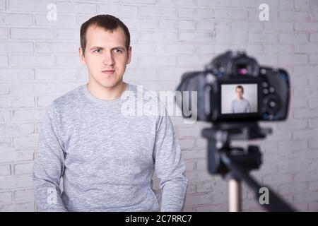 giovane bel blogger uomo registrare video a casa Foto Stock