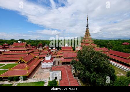 Vista ad alto angolo del Palazzo reale di Mandalay. Edifici retrò rossi e dorati e prato sotto nuvole blu cielo bianco. Grandangolo Foto Stock