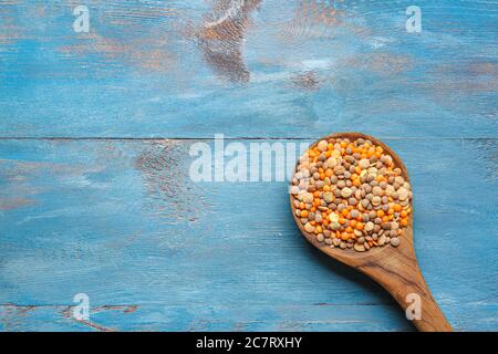 Cucchiaio con lenticchie grezze sul tavolo Foto Stock