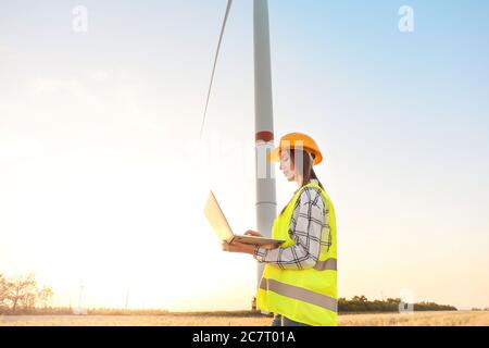 Ingegnere femminile in azienda agricola di mulini a vento per la produzione di energia elettrica Foto Stock