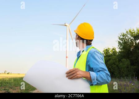 Ingegnere maschile in azienda agricola mulino a vento per la produzione di energia elettrica Foto Stock