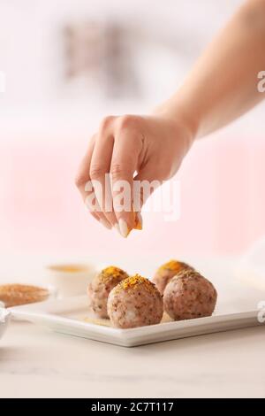 Donna che prepara onigiri giapponesi tradizionali in cucina Foto Stock