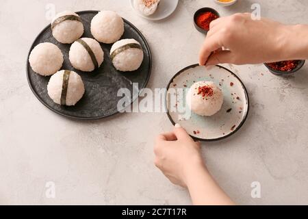 Donna che prepara onigiri giapponesi tradizionali sul tavolo Foto Stock