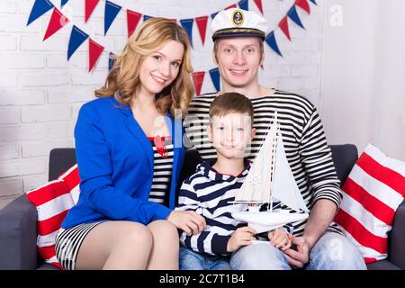 ritratto di felici giovani genitori e figlio in uniforme marinai Foto Stock