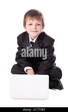 piccolo ragazzo carino in tuta da lavoro con computer portatile isolato su sfondo bianco Foto Stock